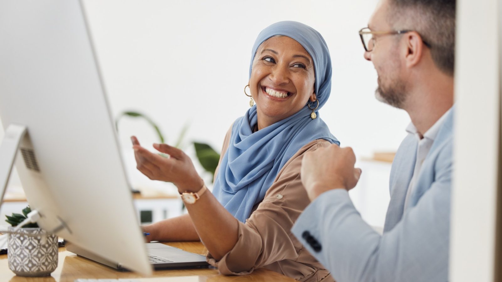 Woman laughing with man at a computer